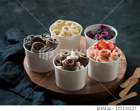rolled ice creams in cone cups on dark background rolled ice creams in cone cups on dark background 115150227