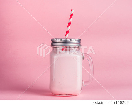 strawberry smoothie in mason jar glass on pink strawberry smoothie in mason jar glass on pink 115150295