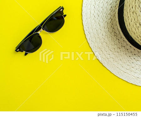 Flatlay, summer vacation. Straw hat and sunglasses on a yellow background. 115150455