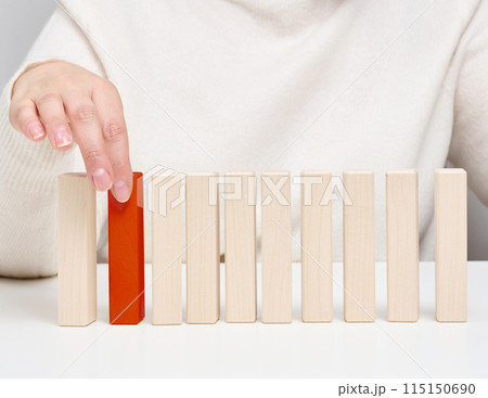 Wooden blocks on the table, a woman's hand holds one. The concept of finding unique Wooden blocks on the table, a woman's hand holds one. The concept of finding unique 115150690