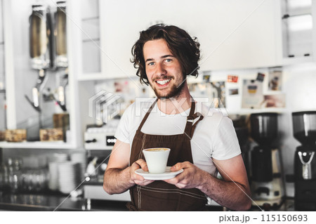 Handsome barista working in coffee shop, preparing coffee. University student working part-time in cafe. Handsome barista working in coffee shop, preparing coffee. University student working part-time in cafe. 115150693