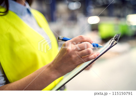 Manager woman in business casual clothes controlling goods in warehouse. Manager woman in business casual clothes controlling goods in warehouse. 115150791