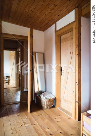 Interior of living room in vintage rustic style with wooden doors and doorframes in a cottage, family house. Interior of living room in vintage rustic style with wooden doors and doorframes in a cottage, family house. 115150806