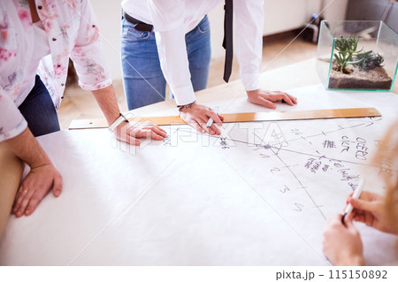 Close up on hands of people working on a new project together in a startup company office. Working in co-working space. Close up on hands of people working on a new project together in a startup company office. Working in co-working space. 115150892