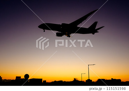 夕焼けの中着陸する飛行機 福岡空港 787 115151598