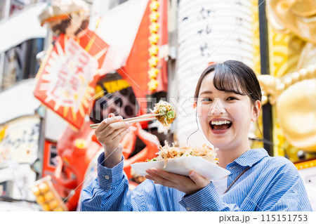 大阪道頓堀で名物のたこ焼きを食べる女性 115151753
