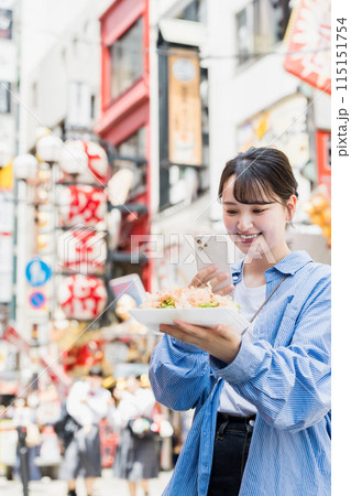 大阪道頓堀で名物のたこ焼きを食べる女性 大阪道頓堀で名物のたこ焼きを食べる女性 115151754