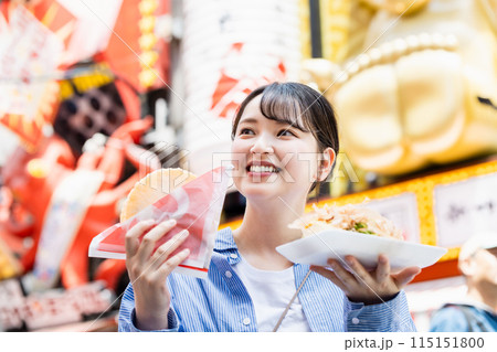 大阪道頓堀で名物のたこ焼きとたこせんを食べる女性 115151800