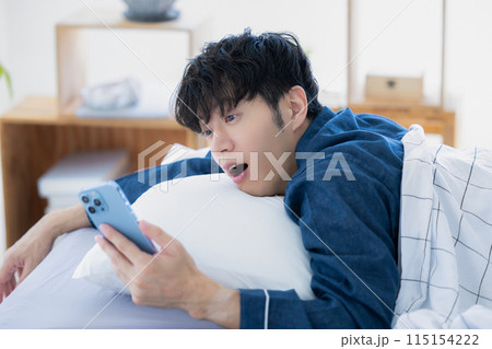寝坊して時計を見ている男性 115154222