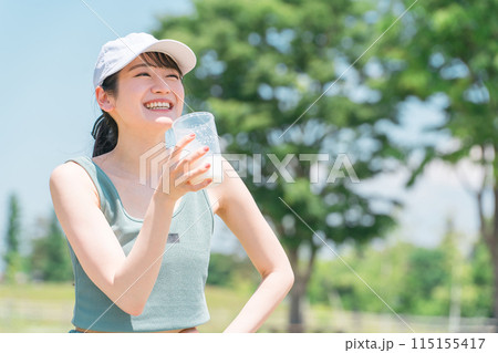 公園でトレーニングしながらプロテインを飲む女性 115155417