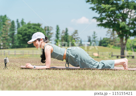 公園でヨガマットを使ってヨガ・ストレッチ・運動をする女性(坂のポーズ・腕立て伏せ) 公園でヨガマットを使ってヨガ・ストレッチ・運動をする女性(坂のポーズ・腕立て伏せ) 115155421