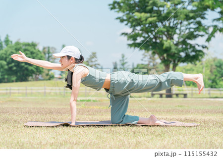 公園でヨガマットを使ってヨガ・ストレッチ・運動をする女性(トラのポーズ) 公園でヨガマットを使ってヨガ・ストレッチ・運動をする女性(トラのポーズ) 115155432
