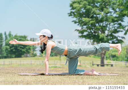 公園でヨガマットを使ってヨガ・ストレッチ・運動をする女性(トラのポーズ) 公園でヨガマットを使ってヨガ・ストレッチ・運動をする女性(トラのポーズ) 115155433