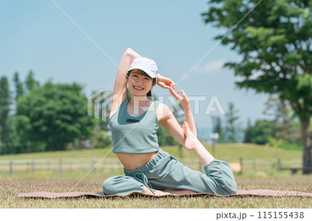 公園でヨガマットを使ってヨガ・ストレッチ・運動をする女性（マーメイドポーズ） 115155438