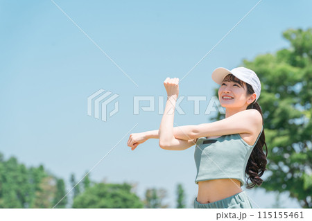 公園でストレッチ・準備体操・ウォーミングアップするスポーツウェア姿の若いアジア人女性 115155461