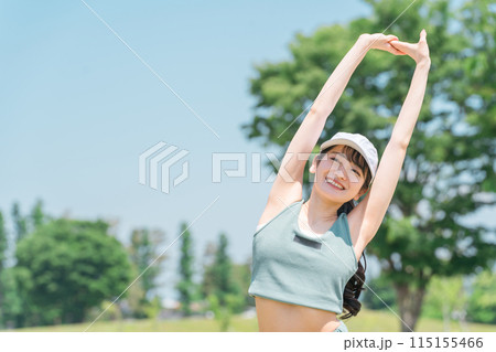 公園でストレッチ・準備体操・ウォーミングアップ・深呼吸するスポーツウェア姿の若いアジア人女性 115155466