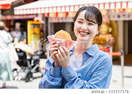 大阪道頓堀で名物のたこせんを食べる女性 115157178