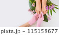 Beautiful perfect female skin legs feet top view with tropical flowers and green palm leaf. Nail polish, care and clean, spa pedicure treatment in white. Concept on background isolated. Copy space 115158677