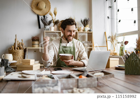 Caucasian man potter happy with online sale of bowl on Internet. 115158992