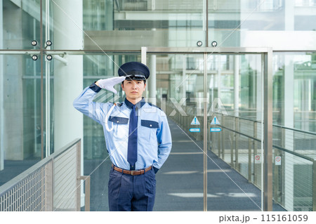 エントランスに立って敬礼する警備員 115161059