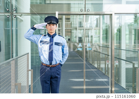 エントランスに立って敬礼する警備員 115161060