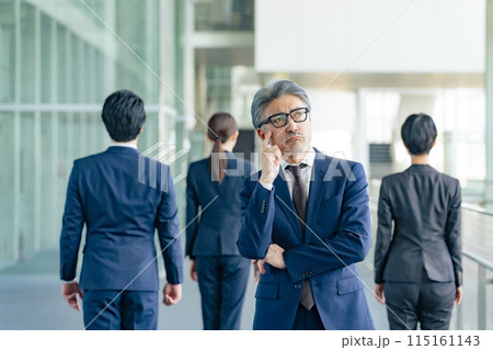 部下に背を向けて悩むシニア男性ビジネスパーソン 115161143