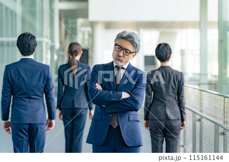 部下に背を向けて悩むシニア男性ビジネスパーソン 部下に背を向けて悩むシニア男性ビジネスパーソン 115161144
