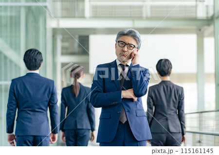 部下に背を向けて悩むシニア男性ビジネスパーソン 部下に背を向けて悩むシニア男性ビジネスパーソン 115161145
