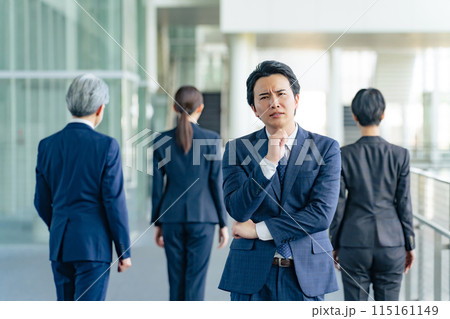同僚に背を向けて悩む男性ビジネスパーソン 115161149