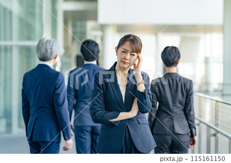 同僚に背を向けて悩むミドル女性ビジネスパーソン 同僚に背を向けて悩むミドル女性ビジネスパーソン 115161150