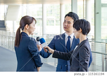 メディアに囲まれてインタビューを受けるミドル女性 115161194
