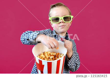Cute fun kid baby boy 4 year old in red t-shirt holding bucket for popcorn 115163415
