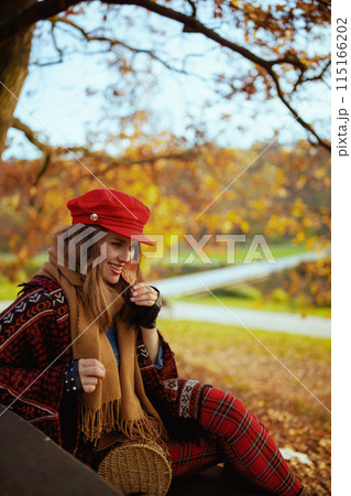 smiling elegant 40 years old woman in red hat with autumn leaf 115166202