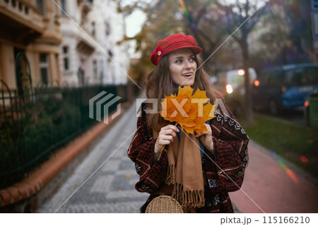 happy stylish woman in red hat walking 115166210