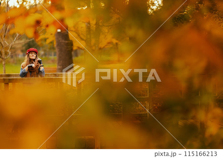 relaxed elegant 40 years old woman in jeans shirt and red hat 115166213