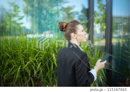 happy female worker in business district using smartphone happy female worker in business district using smartphone 115167883