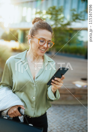smiling modern woman worker in green blouse and eyeglasses 115167896