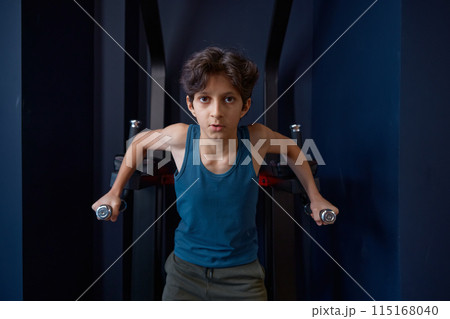 Sporty preteen boy training abs demonstrating strength and power Sporty preteen boy training abs demonstrating strength and power 115168040