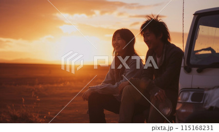 日没時に日本人のボーイフレンドと一緒に車の前に座っている笑顔の日本人女性 115168231