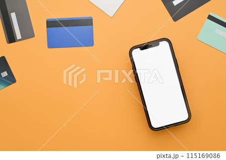 Smartphone with blank screen and bank cards on yellow background. Modern payment systems concept Smartphone with blank screen and bank cards on yellow background. Modern payment systems concept 115169086