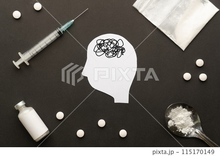 Drug addiction induced psychosis. Human brain feeling confused symbol with drug powder, syringe and pills on dark background. International Day against Drug Abuse. 115170149