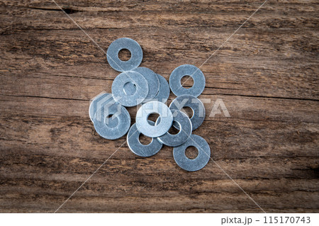 Bunch of flat washer on a dark wood texture background 115170743