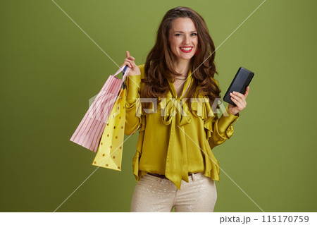 happy modern female using smartphone on green background happy modern female using smartphone on green background 115170759