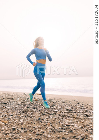 Young fitness woman in sports clothing running by the sea 115172034