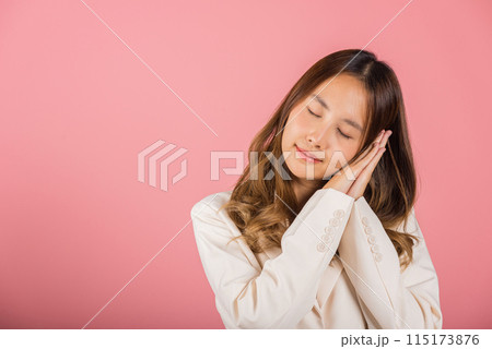 Portrait Asian beautiful young woman pretended emotions sleeping tired eyes closed dreaming with hands together near face, studio shot on pink background, with copy space, insomnia concept 115173876