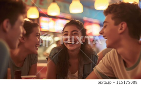 Laughing teenagers chatting at a table in a cafe. Laughing teenagers chatting at a table in a cafe. 115175089