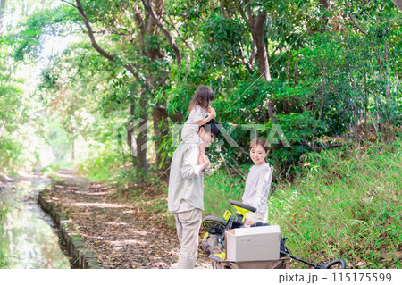 森の中でアウトドアカートを使う家族 115175599