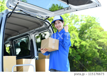 外で荷物を運ぶ配送ドライバーの女性 115176673