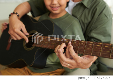 Father Teaching Son Playing Guitar Father Teaching Son Playing Guitar 115176907