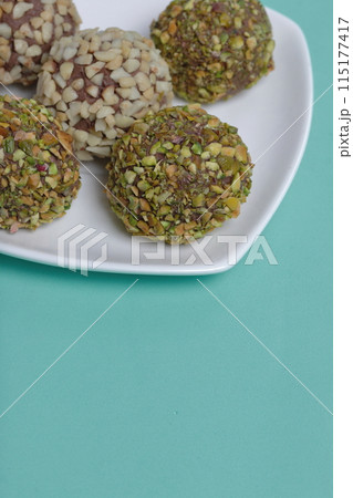 Homemade sweets. Chocolate truffles with a crumb of peanuts and pistachios. 115177417